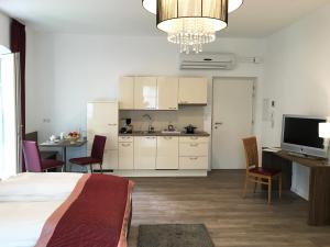 a bedroom with a bed and a kitchen with a table at Villa Caldarum in Caldaro