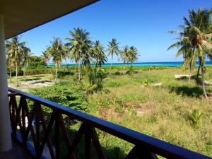a balcony with a view of the ocean and palm trees at Shamar Guesthouse & Dive in Maamigili