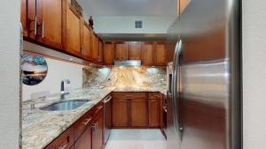 a kitchen with wooden cabinets and a stainless steel refrigerator at Crescent Cove 87 at Palmas in Humacao