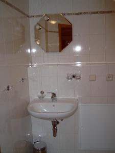 ein weißes Badezimmer mit einem Waschbecken und einem Spiegel in der Unterkunft FH Alfred in Freyburg