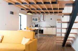 a living room with a yellow couch and a kitchen at Casa do Largo do Cruzeiro in Vouzela