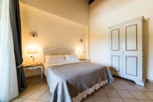 ein Schlafzimmer mit einem Bett, zwei Lampen und einer Tür in der Unterkunft Tenuta D'Amore in San Mango Piemonte