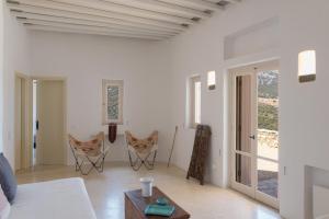 a white living room with a table and chairs at Katavati - 2 Semi-detached Houses in Apollonia