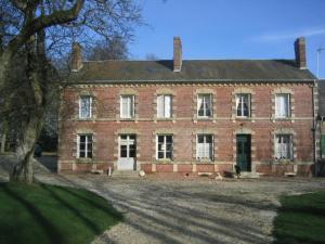 une vieille maison en briques avec un arbre devant elle dans l'établissement Chez Francine et Xavier, à Froissy