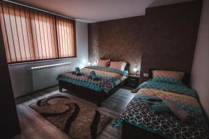 1 dormitorio con 2 camas y ventana en Kristal Apartmani en Arandjelovac