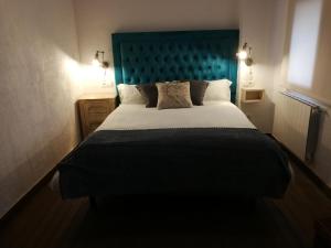 a bedroom with a large bed with a blue headboard at BAVIECA-MARIMEDRANO 12 in Medinaceli