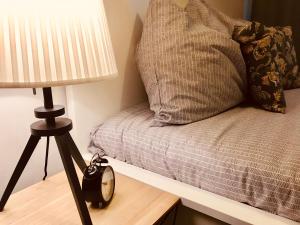 une lampe assise à côté d'un lit avec un oreiller dans l'établissement Apartament Bulwary Warty, à Śrem