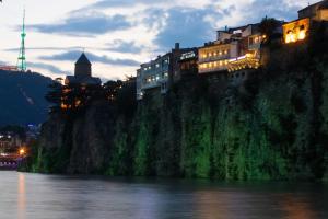 a group of buildings on a hill next to a river at Boutique Hotel in Tbilisi City