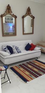 a white couch in a living room with two mirrors at Charmoso Apartamento Leme/copacabana in Rio de Janeiro
