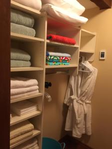a closet with white shelves and towels at Garden Bridge House in Sechelt +45 photos