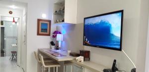 sala de estar con TV de pantalla plana grande en la pared en Charmoso Apartamento Leme/copacabana, en Río de Janeiro