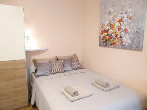 a bedroom with a bed with two towels on it at Sunray Studio Apartment in Zagreb