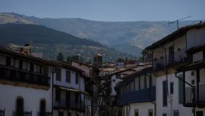 a group of buildings with mountains in the background at Posada Puerta Grande in Candelario