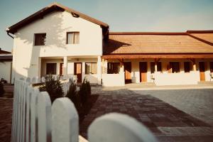 une clôture blanche devant une maison dans l'établissement Pensiunea Rustic, à Hunedoara