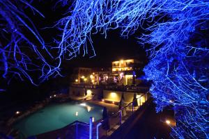 a house with a pool at night with blue lights at Hotel Villa Margherita in Quercianella