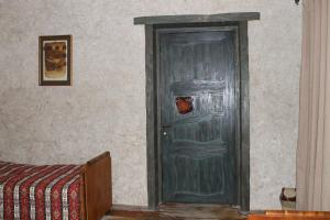 Master's House Dayan في يريفان: باب أخضر في غرفة بسرير