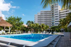 
a large swimming pool in front of a large building at Hotel Calypso Cancun in Cancún
