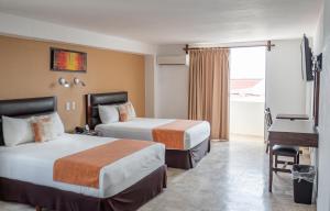 a hotel room with two beds and a desk at Hotel Calypso Cancun in Cancún