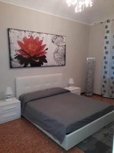 um quarto com uma cama com uma flor vermelha na parede em IL PORTONE VERDE em Turim