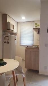 uma pequena cozinha com uma mesa e um frigorífico em Solar Água 172 em Pipa