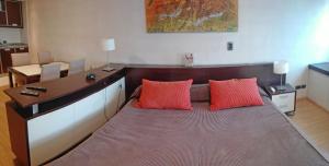 1 cama con 2 almohadas rojas en una habitación en Recoleta SUITE en Buenos Aires