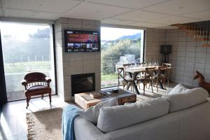 a living room with a couch and a fireplace at 157 Field Way Luxury Lodge in Waikanae
