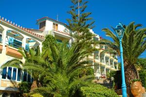 a building with palm trees in front of it at Rethymno Mare Royal & Water Park in Skaleta