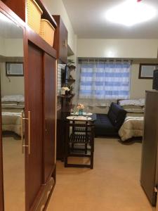 a room with a table and a living room with beds at Joaquim Vacation Homes in Davao City