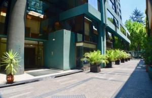 Un edificio con plantas en macetas en frente de él. en Luigi's Apart Hotel, en Santiago