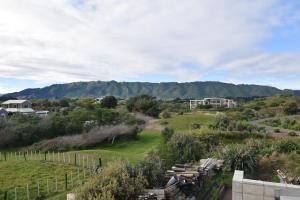 Elle offre une vue sur un jardin avec des montagnes en arrière-plan. dans l'établissement 157 Field Way Luxury Lodge, à Waikanae