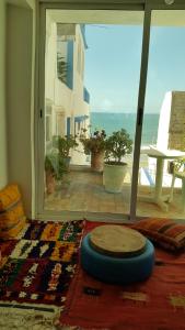 um quarto com uma mesa e vista para o oceano em tamazirt surf house em Taghazout