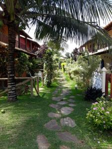 um caminho que leva a uma casa com uma palmeira em Casa Praia Rasa em Búzios