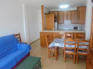 Una habitación con cocina, mesa y sillas. en Apartamento en la Playa de San José-sjjc, en San José