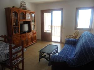 Una sala de estar con un sofá y un televisor. en Apartamento en la Playa de San José-sjjc, en San José