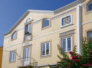 a building with a clock on the side of it at Casa da Parede - Beach & Mountain in Parede