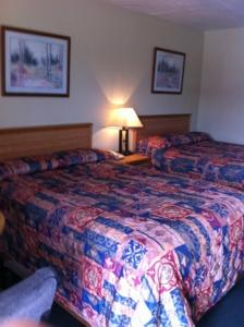 una habitación de hotel con 2 camas y una lámpara en Gold Inn en Hutchins