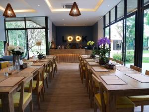 uma fila de mesas e cadeiras num restaurante em Look at Home Lamphun em Lamphun