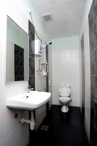 uma casa de banho branca com um lavatório e um WC em Hotel Rembia em Rembia