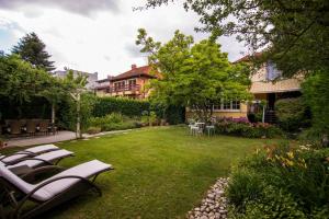a garden with lawn chairs and a house at Nebo in Zagreb