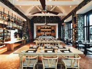 uma sala de jantar com mesas e cadeiras e uma sala com barris de vinho em Park Hyatt St. Kitts em Christophe Harbour
