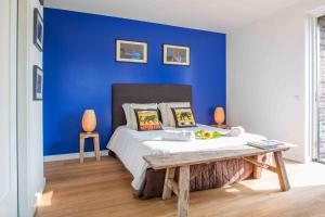 een blauwe slaapkamer met een bed en een blauwe muur bij Amsterdam Area Residence Oosterwold in Almere