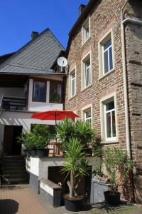 a brick building with a red umbrella in front of it at Ferienweingut SerwaziWein in Mesenich