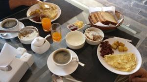 a table topped with plates of breakfast foods and a cup of coffee at Bandipur Kaushi Inn in Bandipur