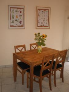 una mesa de madera con sillas y un jarrón de flores. en Ferienweingut SerwaziWein en Mesenich