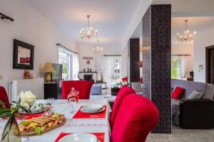 a living room with a table with food and red chairs at Ekaterini Vip Villa in Plaka