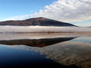 ein Berg inmitten eines Wasserkörpers in der Unterkunft Apartments Vrdjan in Cerknica