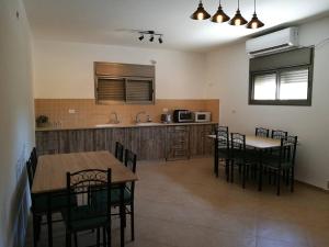 eine Küche mit 2 Tischen und Stühlen sowie einer Theke in der Unterkunft Mool Gilboa - מול גלבוע in Bet Scheʼan