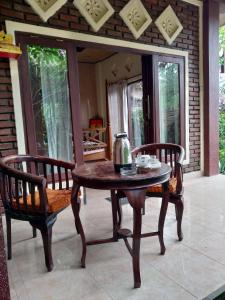 een tafel en twee stoelen met een waterkoker erop bij Umah Ubud B&B in Ubud