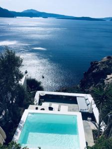 a swimming pool with a view of the water at Ifestio Villas Oia in Oia