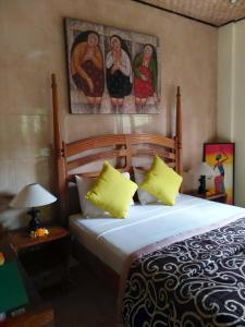 een slaapkamer met een bed en een schilderij aan de muur bij Umah Ubud B&B in Ubud